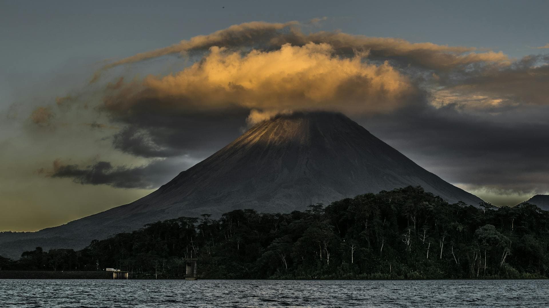 Arenal volcano at sunset with cloud forest and lake